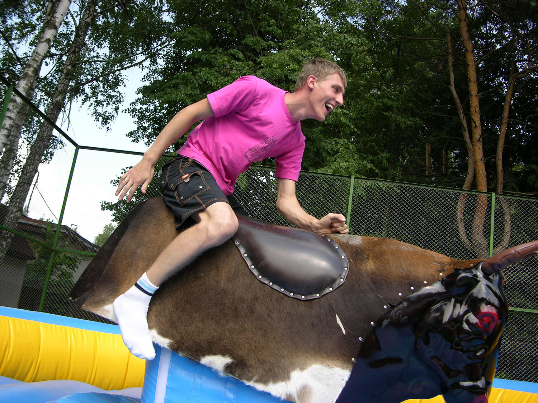 Young man laughing, riding on a mechanical bull - Decatur, IL